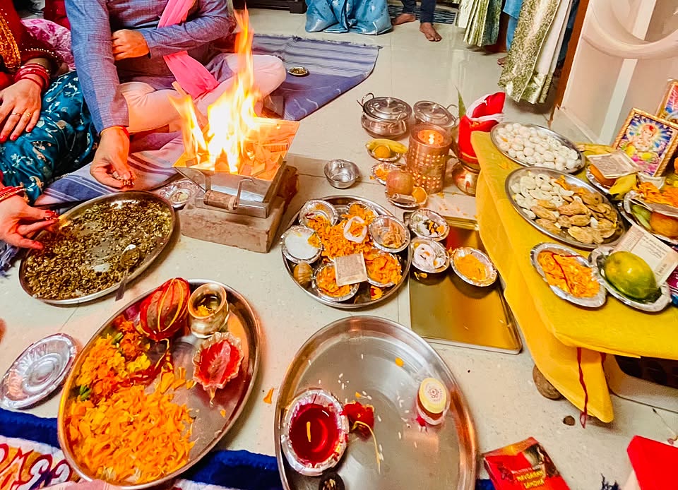 Havan fire burning in the kund with thalis of samagri and prasad at a home puja in Delhi NCR
