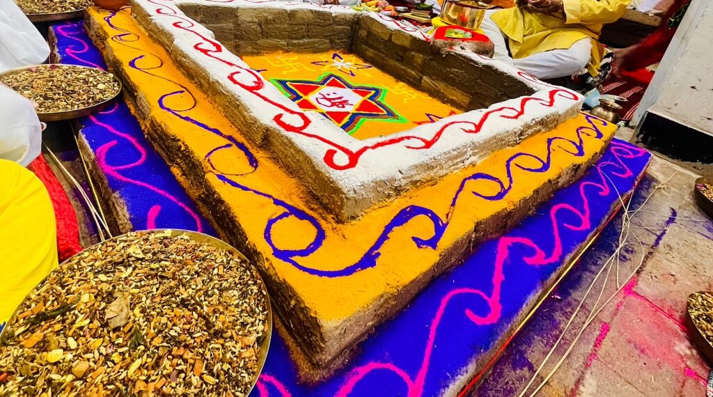 Large havan kund with a hand-drawn rangoli border and havan samagri for a Navgraha Shanti Puja