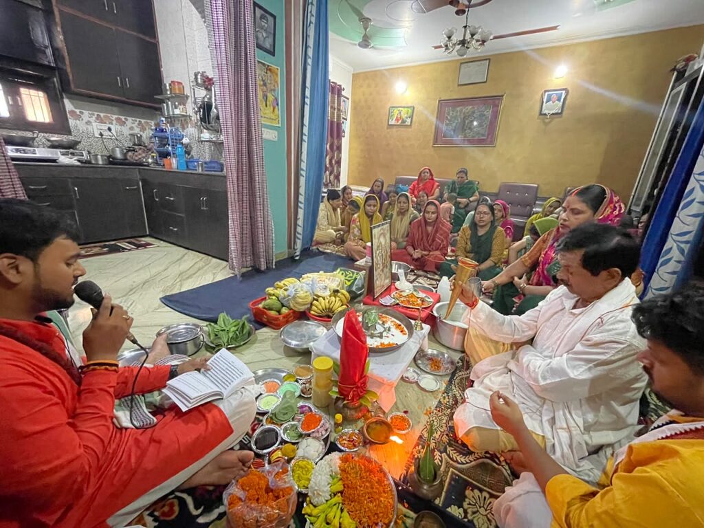 Vandanam pandit reciting mantras during a Navgraha Shanti Puja with the family gathered at home