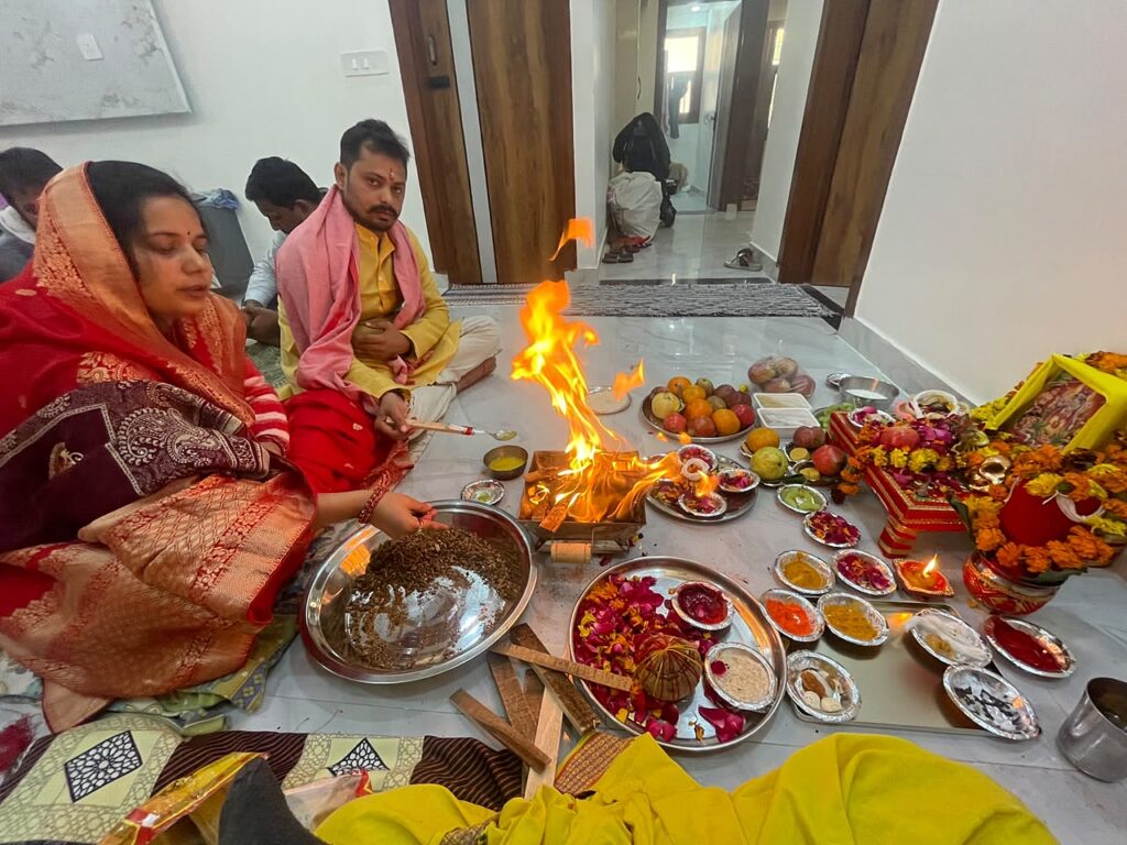 A woman offering ahuti into the havan fire during a Navgraha Shanti Puja at her home in Delhi NCR